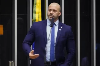 O ministro Alexandre de Moraes, do Supremo Tribunal Federal (STF), autorizou nesta segunda-feira (29) a progressão de regime do ex-deputado Daniel Silveira para o aberto. A decisão seguiu parecer da Procuradoria-Geral da República (PGR), que destacou o cumprimento de parte da pena e o comportamento carcerário do condenado. Progressão de regime concedida com restrições A PGR reconheceu que Silveira já cumpriu 25% da condenação e apresentou boa conduta, requisitos que permitem a progressão de regime. No parecer, o vice-procurador-geral da República, Hindenburgo Chateaubriand Filho, recomendou o benefício ao STF. Apesar da concessão, Moraes estabeleceu medidas rigorosas para o cumprimento da pena em regime aberto. Entre elas estão o uso obrigatório de tornozeleira eletrônica, recolhimento domiciliar à noite e nos fins de semana, além da proibição de deixar a comarca sem autorização judicial. O ministro também determinou que o ex-deputado se apresente semanalmente à Justiça e não utilize redes sociais. No despacho, Moraes deixou claro que qualquer descumprimento pode resultar na regressão da pena. O ministro ressaltou que, caso haja falta grave ou prática de novo crime, Silveira poderá retornar a regimes mais severos. Daniel Silveira foi condenado a oito anos e nove meses de prisão por crimes contra o Estado Democrático de Direito. Desde então, sua situação processual tem sido marcada por avanços e retrocessos em relação às condições de cumprimento da pena. Histórico de violações anteriores Em dezembro do ano passado, Silveira havia recebido liberdade condicional, mas perdeu o benefício poucos dias depois. Segundo a decisão de Moraes, ele descumpriu o horário de recolhimento domiciliar já no primeiro dia, retornando para casa após o limite fixado pela Justiça. Essa reincidência pesou na análise do ministro, que reforçou no atual despacho que a progressão de regime só será mantida se todas as condições impostas forem respeitadas integralmente.