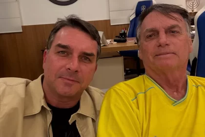 O senador Flávio Bolsonaro (PL-RJ) confirmou nesta sexta-feira, 5, que irá disputar a Presidência da República em 2026. O anúncio, feito por meio de publicação no X, movimentou o cenário político nacional e marca a entrada oficial do parlamentar na corrida ao Palácio do Planalto. Flávio Bolsonaro anuncia decisão e cita apoio de Jair Bolsonaro Segundo Flávio Bolsonaro, a candidatura foi motivada pela confiança e pelo aval de seu pai, o ex-presidente Jair Bolsonaro, atualmente preso na Superintendência da Polícia Federal em Brasília por ordem do ministro Alexandre de Moraes, do Supremo Tribunal Federal (STF). O senador declarou que recebeu a missão de dar continuidade ao projeto político que a família construiu nos últimos anos, ressaltando que pretende atuar para enfrentar o que chamou de instabilidade e insegurança no país. O presidente nacional do PL, Valdemar Costa Neto, já havia antecipado a escolha, afirmando que a decisão estava consolidada dentro da legenda. O dirigente reforçou que o partido seguirá unificado em torno da nova candidatura. Impactos da candidatura de Flávio Bolsonaro no cenário da direita A confirmação de Flávio Bolsonaro altera os arranjos internos da direita para 2026. A entrada do senador na disputa presidencial deve levar o governador de São Paulo, Tarcísio de Freitas, a concentrar esforços na própria reeleição, descartando uma eventual candidatura ao Planalto. A decisão também interfere nos planos eleitorais iniciais do próprio parlamentar. Até esta sexta-feira, Flávio era cotado pelo PL para disputar novamente o Senado pelo Rio de Janeiro. Com o partido decidindo apoiar a candidatura de Cláudio Castro ao cargo, abre-se espaço para novas articulações, como o interesse já manifestado pelo deputado Carlos Jordy. Trajetória política de Flávio Bolsonaro e o contexto envolvendo Jair Bolsonaro A candidatura de Flávio Bolsonaro surge em um momento em que Jair Bolsonaro permanece inelegível e cumprindo pena na PF. O ex-presidente foi condenado a 27 anos de prisão pela 1ª Turma do STF, em ação relacionada à suposta tentativa de golpe. Ele também se tornou inelegível em 2023, após decisão do Tribunal Superior Eleitoral. Foi da própria cela na PF que Jair Bolsonaro teria indicado Flávio como representante da família na disputa presidencial. Essa escolha marca uma mudança significativa, já que Jair concorreu nas últimas duas eleições, vencendo em 2018 e sendo derrotado em 2022 por Luiz Inácio Lula da Silva no segundo turno. Quem é Flávio Bolsonaro: trajetória até 2026 Natural do Rio de Janeiro, Flávio Bolsonaro tem 44 anos e iniciou sua vida pública em 2002, quando foi eleito deputado estadual pela primeira vez. Permaneceu na Alerj por quatro mandatos consecutivos. Em 2018, migrou para o Senado Federal, onde foi eleito com mais de 4 milhões de votos, o maior número registrado no estado naquela disputa. Sua atuação no Congresso e sua proximidade com o ex-presidente consolidaram sua influência dentro do PL. Com o anúncio, ele passa a integrar o grupo de pré-candidatos à Presidência em 2026. Além dele, já manifestaram interesse o atual presidente Lula, pelo PT; o governador de Minas Gerais, Romeu Zema (Novo); e o governador de Goiás, Ronaldo Caiado (União Brasil).